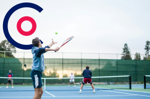 Man about to serve tennis ball with Coordinate Sport logo floating in the background