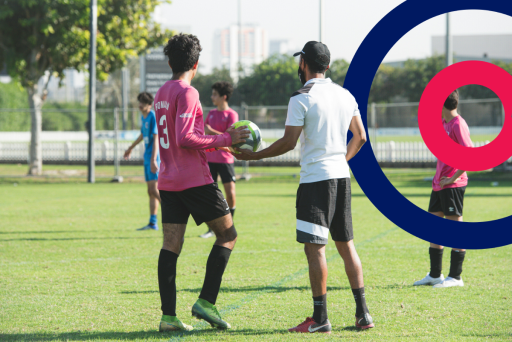 Boy being coached for football with Coordinate logo in the background