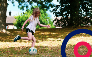 Young girl playing football in her garden with the Coordinate logo in the bottom right